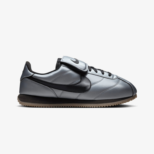 NIKE | CORTEZ { MTLC COOL GREY/BLACK-GUM DARK BROWN